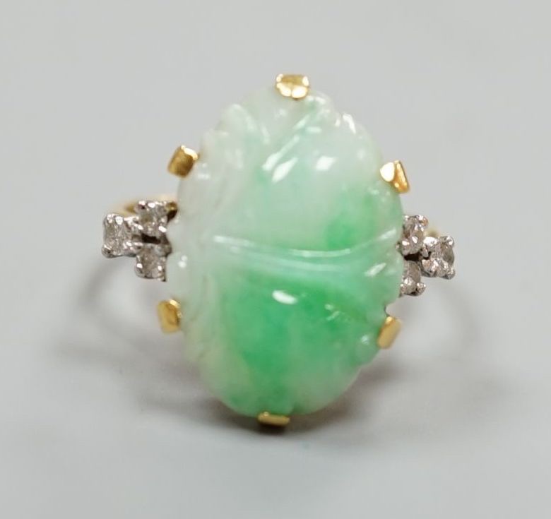 An 18ct, carved jade cabochon and diamond set oval dress ring, size O, gross weight 6.2 grams.